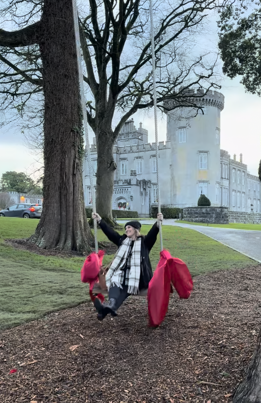 Sara on a swing in front of a castle in Ireland